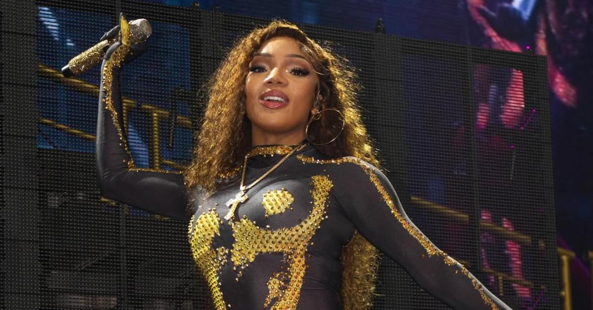 GloRilla performing wearing a black and gold body suit. 