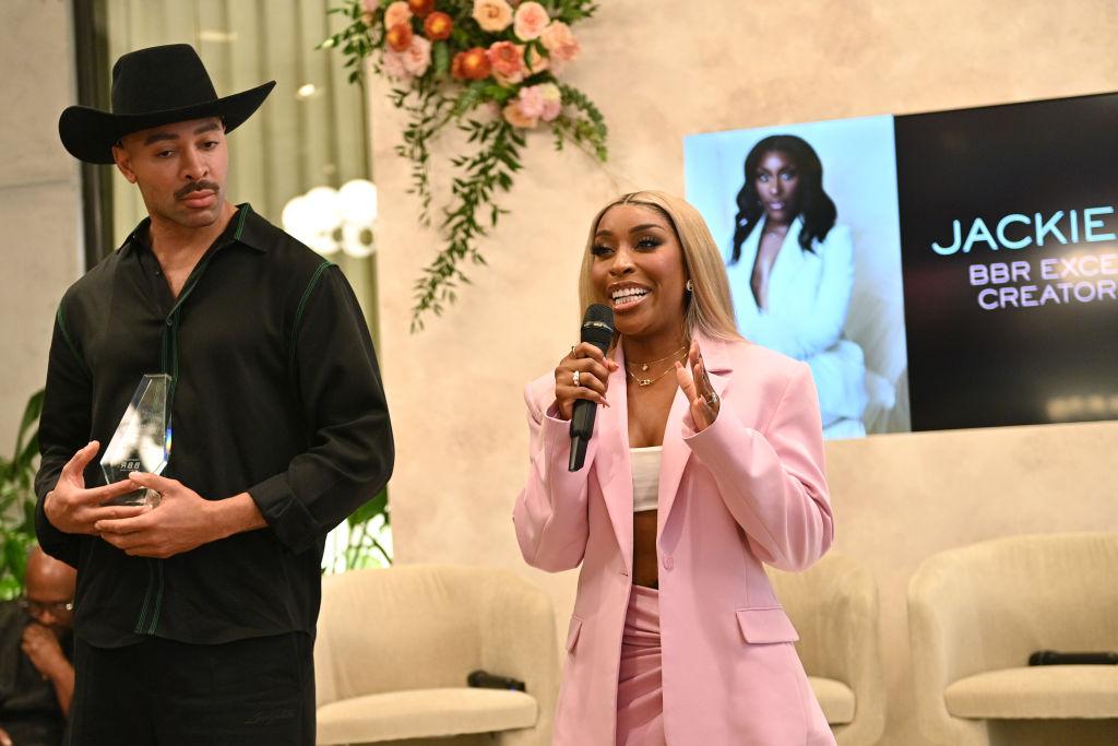 Sir John presents Jackie Aina with an award during the Black Beauty Roster Excellence Awards