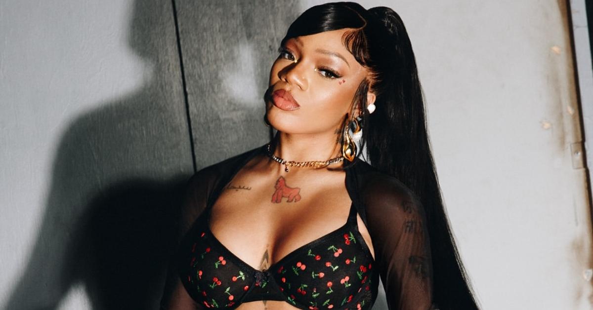 GloRilla is wearing a Savage Fenty bra which is red, green, and black.