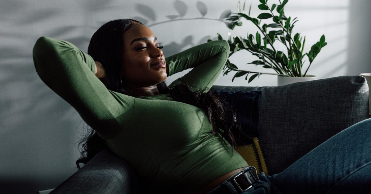 A Black woman relaxing on her couch