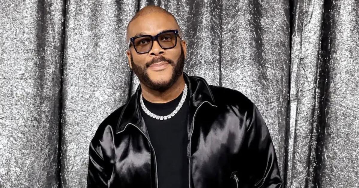 Tyler Perry is wearing a silk black jacket with a black shirt.